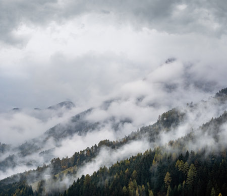 Mystic cloudy and foggy autumn alpine mountain slopes scene. Austrian Lienzer Dolomiten Alps. Peaceful picturesque traveling, seasonal, nature and countryside beauty concept scene.の写真素材