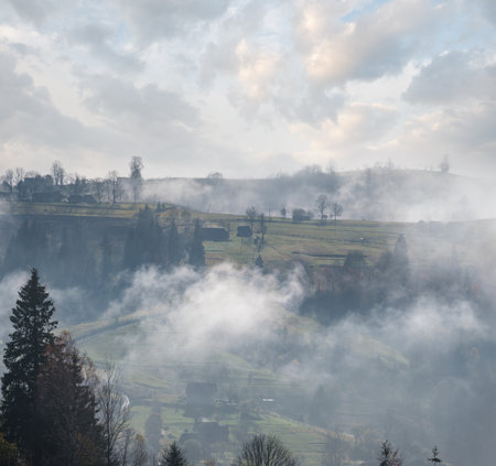 Morning foggy clouds in autumn mountain countryside.  Ukraine, Carpathian Mountains, Transcarpathia. Peaceful picturesque traveling, seasonal, nature and countryside beauty concept scene.の写真素材