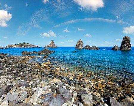 Cyclopean Coast and the Islands of the Cyclops on Aci Trezza town (Italy, Sicily,10 km north of Catania). Known as Isoles Dei Ciclopi Faraglioni.の写真素材