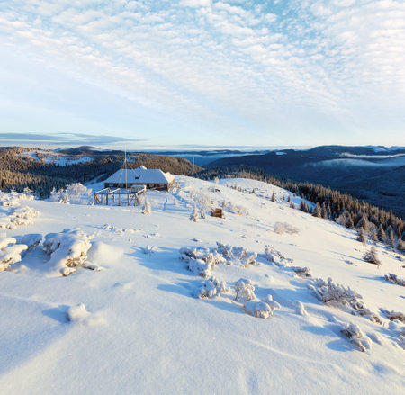 Morning winter mountain landscape with snow covered trees and house on ridgeの写真素材