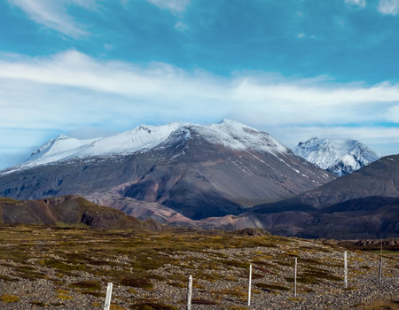 View from highway road during auto trip in Iceland. Spectacular Icelandic landscape with  scenic nature: hamlets, mountains, ocean coast, fjords, fields, clouds, glaciers, waterfalls.の写真素材