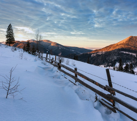 Sunrise morning winter mountain village outskirts. View from rural snow covered path on hill slope, Zelene, Verkhovyna Ukraine.の写真素材