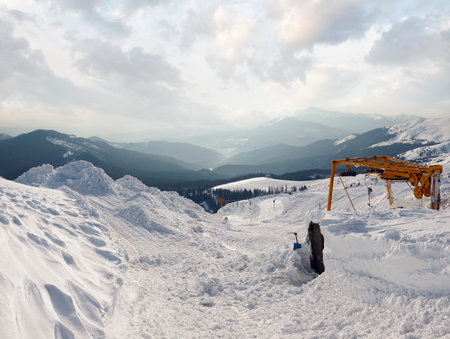 Snow-covered ski hoist ropeway (upper  terminal) and mountain landscape behind (Ukraine, Carpathian Mt's, Drahobrat ski resort). Four shots stitch image.の写真素材