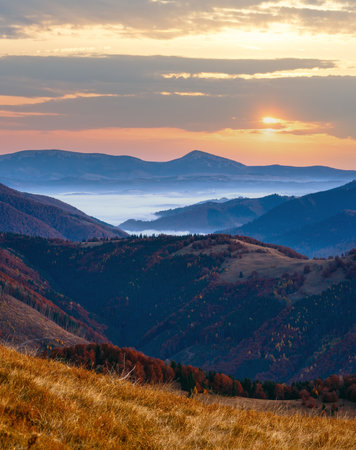 Early dawn in mountains. Autumn morning twilight view with pink sky and mist.の写真素材