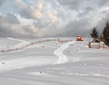 Winter  morning scenery picturesque mountain rural snow covered path and blocked by snow bulldozer on hill top (Ukraine, Carpathian Mountains, tranquility peaceful Dzembronya village outskirts)の写真素材