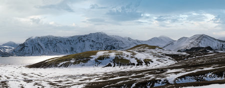 Season change in the Icelandic highlands.  Colorful Landmannalaugar mountains under snow cover in autumn. Frostastadavatn lake at the foot of the mountains.の写真素材
