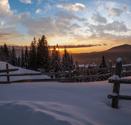 Small and quiet alpine village outskirts and winter sunrise snowy mountains around, Voronenko, Carpathian, Ukraine.の写真素材