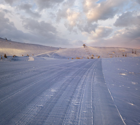 Alpine resort prepared ski slopes and lifts. Pre sunrise morning mountain ridge view. Dragobrat, Ukraine Carpathians.の写真素材