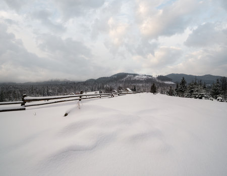 Countryside hills, groves and farmlands in winter remote alpine mountain villageの写真素材