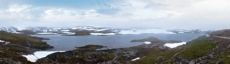 Dense fog and summer mountain landscape with lake and snow (Norway, not far Nigardsbreen glacier). Panorama.の写真素材
