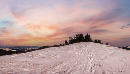 Winter remote alpine mountain village outskirts, countryside hills, groves and farmlands.の写真素材