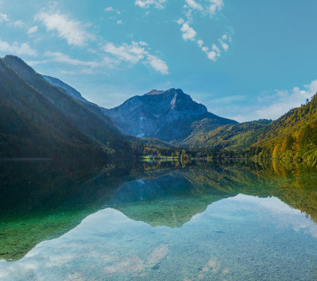 Sunny idyllic colorful autumn alpine view. Peaceful mountain lake with clear transparent water and reflections. Langbathseen lake, Upper Austria.の写真素材