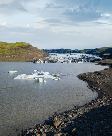 SÃ³lheimajÃ¶kull picturesque glacier in southern Iceland. The tongue of this glacier slides from the volcano Katla. Beautiful glacial lake lagoon with blocks of ice and surrounding mountains.の写真素材