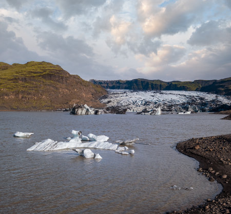 Soheimajokull picturesque glacier in southern Iceland. The tongue of this glacier slides from the volcano Katla. Beautiful glacial lake lagoon with blocks of ice and surrounding mountains.の写真素材