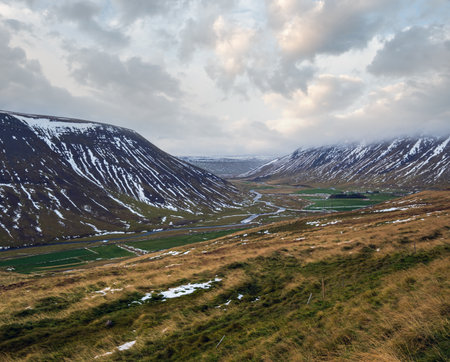 View during auto trip in Iceland. Spectacular Icelandic landscape with  scenic nature: mountains, bottom lands, river, clouds.の写真素材