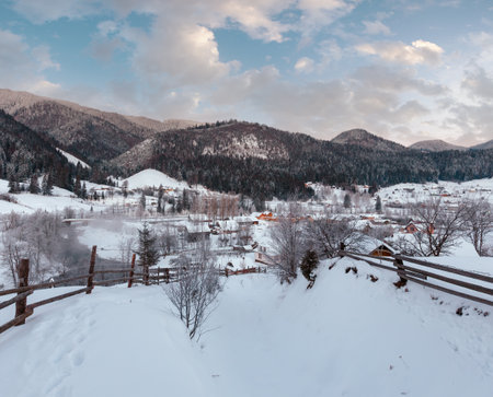 Daybreak morning dusk winter Carpathian mountain village Zelene in Black Cheremosh river valley betwen alp. View from rural snow covered path on hill slope, Verkhovyna district, Ukraine.の写真素材