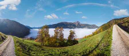 Sunny idyllic autumn alpine scene. Peaceful misty morning Alps mountain view from hiking path from...