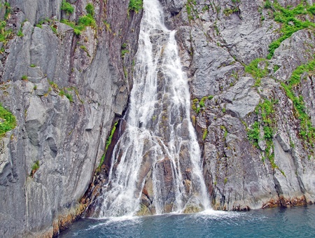 This waterfall is found rushing to the ocean from glaciers in Kenai Fjords National parkの写真素材