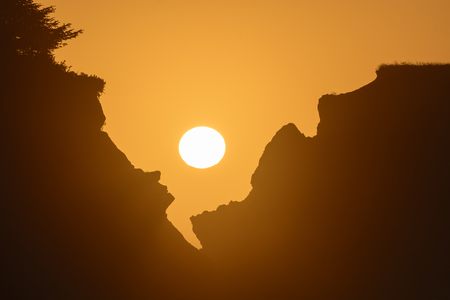 Setting Sun Through the Rocks on the Oregon Coastの写真素材