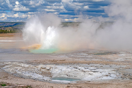 Clepsydra Geyser Erupting in a Volcanic Landscape in Yellowstone National Park in Wyomingの写真素材