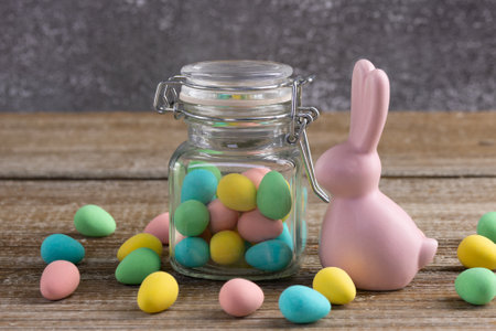 Easter composition on the wooden rustic table with bright colorful chocolate little egg-shape...