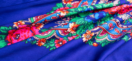 Beautiful blue cotton Russian shawl with vivid floral design, traditional winter scarf background.