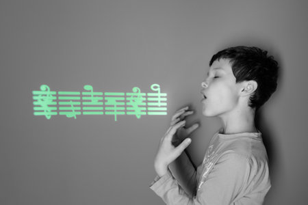 Studio photo with projecting green light on the wall. A concentrated teenager boy is singing a song, gesticulating with his arms.の写真素材