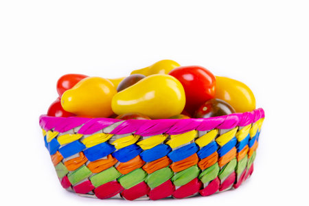 Bright and colorful assorted cherry tomatoes (yellow pear-shaped, red and black striped) in a vivid basket on the white background. Fresh garden produce.の写真素材
