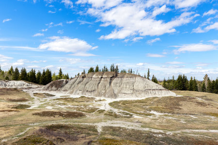 Spring scene in badlands area, eroded hill formations under blue sky and a waving trail. Kleskun Hill natural area, Alberta, Canada.の写真素材