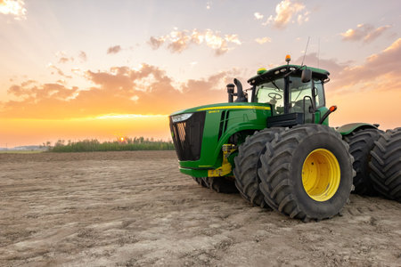 Spirit River, Alberta, Canada - September 12, 2025: Green John Deere tractor 9460R is parked in the field after land rolling in fall. Beautiful orange sunset light.のeditorial素材