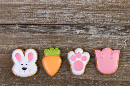 Row of different holiday festive gingerbread cookies with colorful icing on brown rustic wooden...