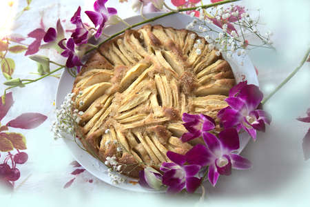 classic cake made with apples surrounded by flowersの写真素材