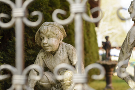 Garden in springtime. A little sunbeam is caressing this statue's knee and the part of its sleeve...の写真素材