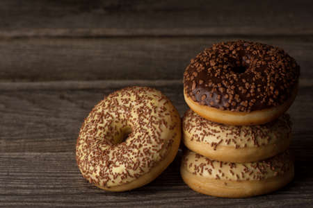 Ring doughnuts covered with vanilla and chocolate glaze, topped with sprinkles.の写真素材