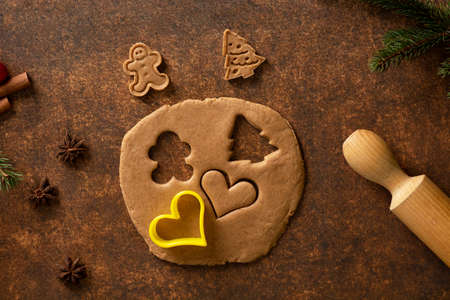 Gingerbread dough is rolled out. Gingerbread cookies are fun to make! They are the essence of the holidays. Gingerbread man cookies, Christmas tree cookies and heart-shaped cookies.の写真素材