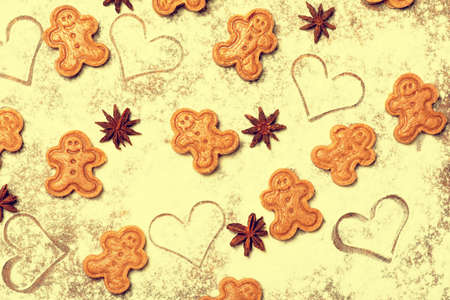 A colourful happy pattern made of unbaked gingerbread man cookies, star anise fruits and seeds and...