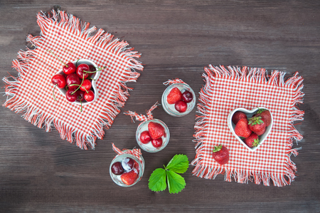 Cherries and strawberries in bowls in the form of hearts,の写真素材