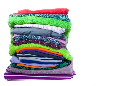 Ironing. Stack of clothing and iron on a white backgroundの写真素材