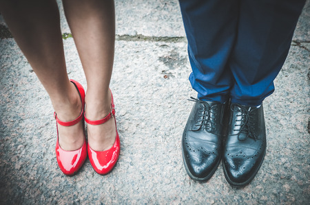 Legs of a man in black shoes and women in red shoes. Romantic couple. In love. Valentine's Day.の写真素材