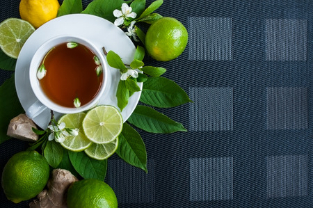 White cup with tea. Green, black, herbal, jasmine tea with lemon and ginger.Background with space for text. Tea theme.の写真素材