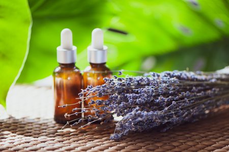 Oil, whey, cream with lavender. Organic cosmetics. A bouquet of lavender and jars on the backgroundの写真素材