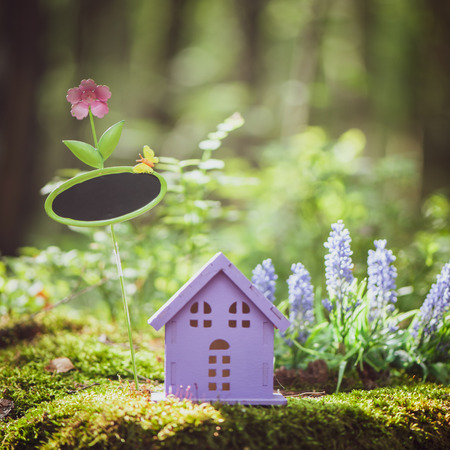 fabulous, toy house, the colors of lavender with a sign for inscription,  against the backdrop of a fairy forest. Concept cozy home, cozy world.の写真素材