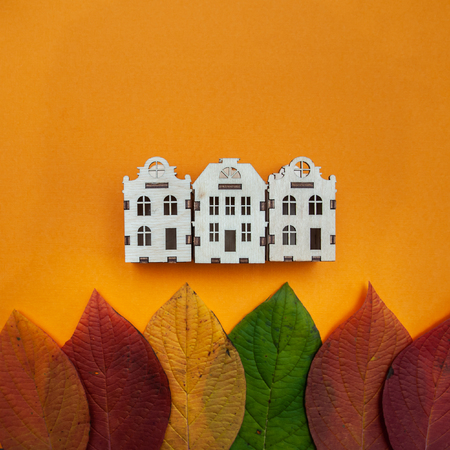 Concept of autumn  city  , colorful leaves  and houses   on an orange background. View from above, flat layの写真素材