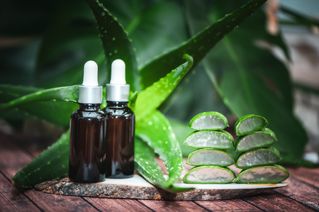 Aloe oil, juicy scarlet cut into pieces on a natural wooden background . Organic bio cosmeticsの写真素材