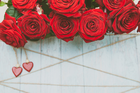 Stylish background on the theme of love, red roses , wooden hearts and twine, space for text, mockupの写真素材