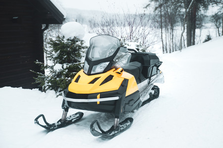 Snowmobile, empty, against the backdrop of the winter forestの写真素材