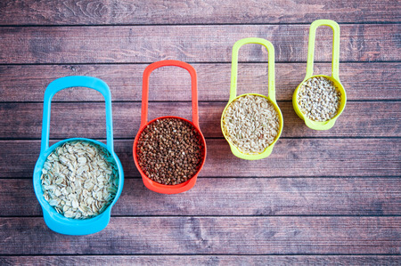 Set of different cereals in multi-colored containers, Oatmeal buckwheat, barley and riceの写真素材