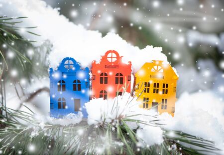 Toy houses  on a natural natural background of a real fir in the snow. Concept of winter, Christmas, new year,
 warm, cozy in the city.の写真素材
