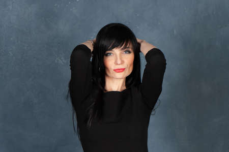 Expressive and glamorous beautiful girl, brunette in a black dress. Beautiful and slender woman...