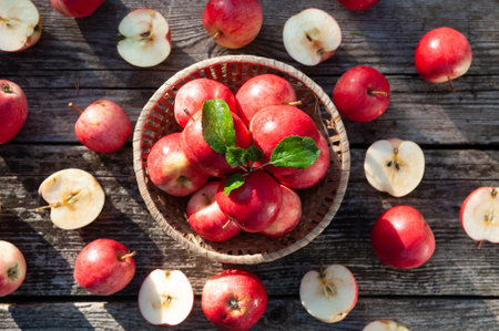 Juicy red apples in a basket on a textured table background and a pattern of apples on the table,...
